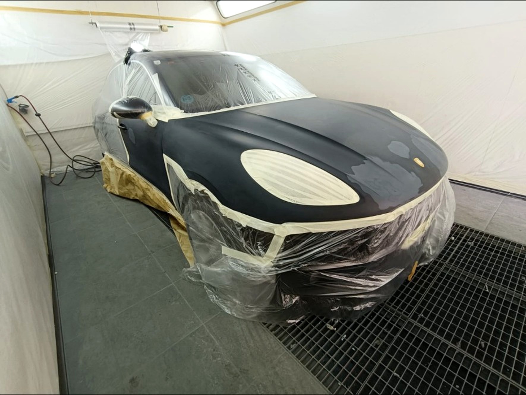 Porsche Macan enmascarado en cabina de pintura, preparación del frontal
